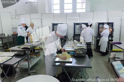 Image of Young cooks prepare food in competition