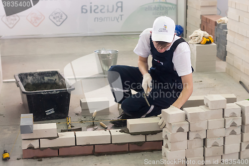 Image of Young bricklayer performs a task of competition