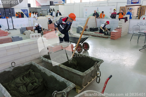 Image of Young bricklayers perform a task of competition