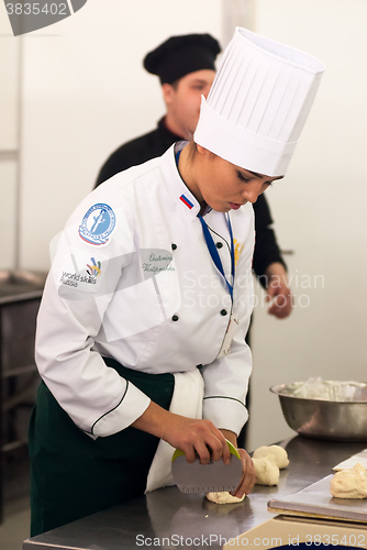 Image of Girl-cook prepares food in competition