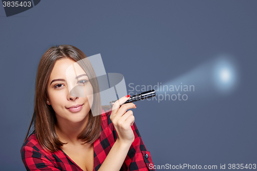 Image of Closeup of smiling female holding pocket flashlight