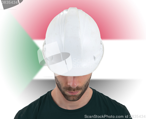 Image of Engineer with flag on background - Sudan