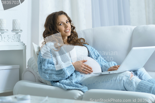 Image of beautiful pregnant woman  and laptop