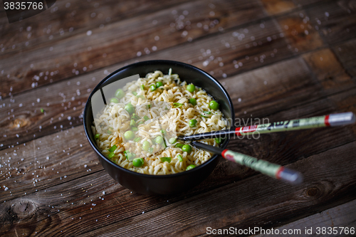 Image of Bowl of noodles with fresh peas and chopped onion.