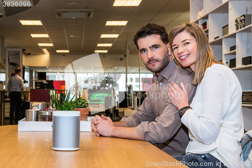 Image of Couple With Speaker On Counter In Electronics Shop