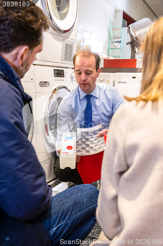 Image of Salesman Showing Cartridge Of Washing Machine In Store