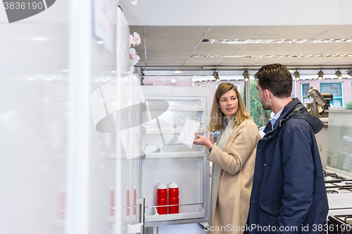 Image of Young Couple Buying Refrigerator In Hypermarket