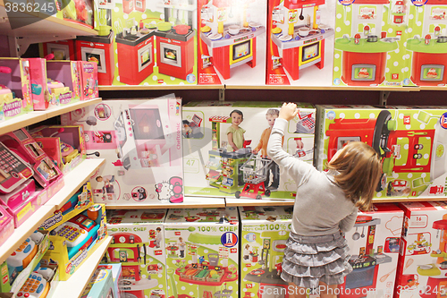 Image of Girl chooses a toy in a toy shop