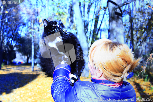 Image of woman with black cat in the autumn park