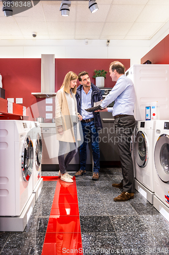 Image of Salesman Explaining Product Quality At Appliances Store