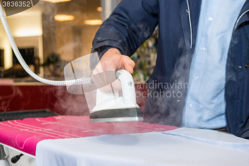 Image of Man Testing Steam Iron Before Buying From Hypermarket