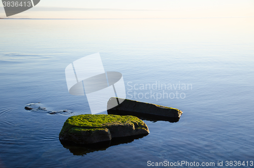 Image of Green rocks in smooth water