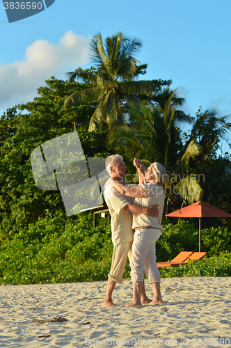 Image of elderly couple dancing at tropical beach