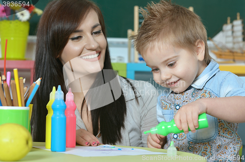 Image of little boy drawing  with mother