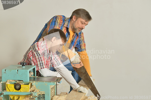 Image of father and little boy  repairing in the room