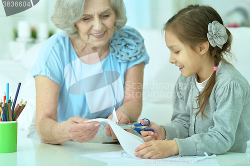 Image of Grandmother with granddaughter cutting together