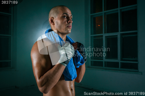 Image of The young man kickboxing on black background