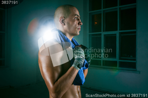 Image of The young man kickboxing on black background