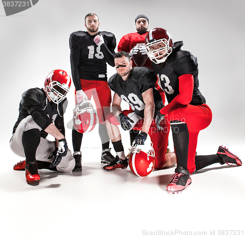 Image of The five american football players posing with ball on white background