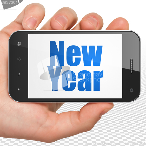 Image of Entertainment, concept: Hand Holding Smartphone with New Year on display