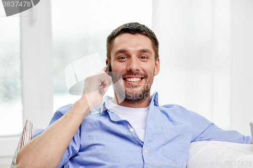 Image of happy man calling on smartphone at home