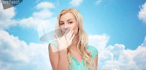 Image of smiling young woman or teen girl covering mouth
