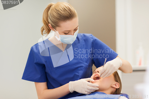 Image of female dentist checking patient girl teeth