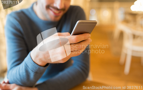 Image of close up of man with smartphones at cafe