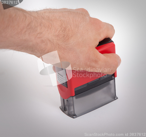 Image of Plastic stamp in hand, isolated