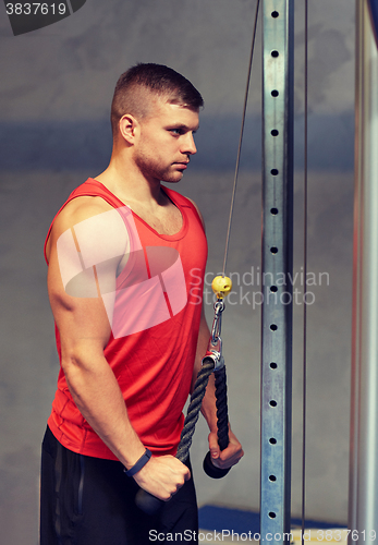 Image of man flexing muscles on cable machine gym