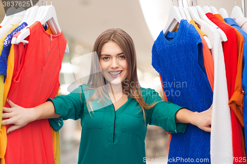 Image of happy woman choosing clothes at home wardrobe