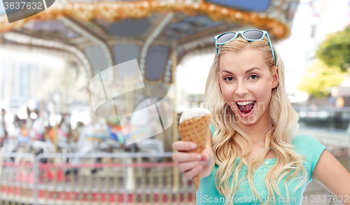 Image of happy young woman in sunglasses eating ice cream