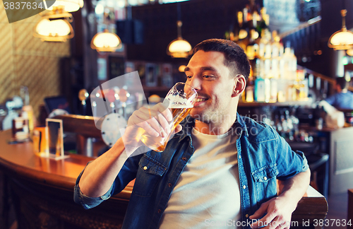 Image of happy man drinking beer at bar or pub