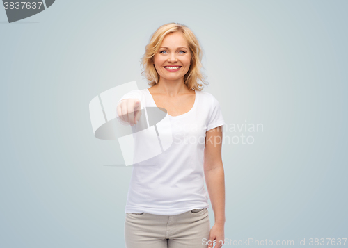 Image of smiling woman in white t-shirt pointing to you