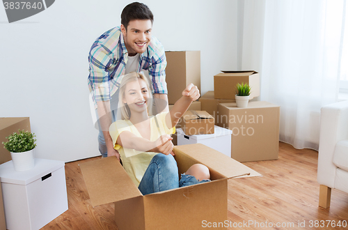 Image of happy couple having fun with boxes at new home