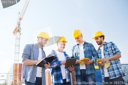 Image of group of smiling builders with tablet pc outdoors