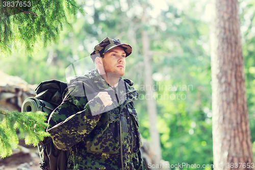 Image of young soldier with backpack in forest