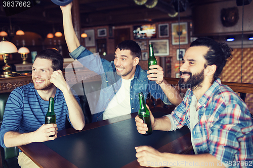 Image of happy male friends drinking beer at bar or pub