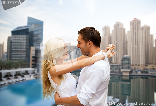 Image of happy couple hugging over dubai city background