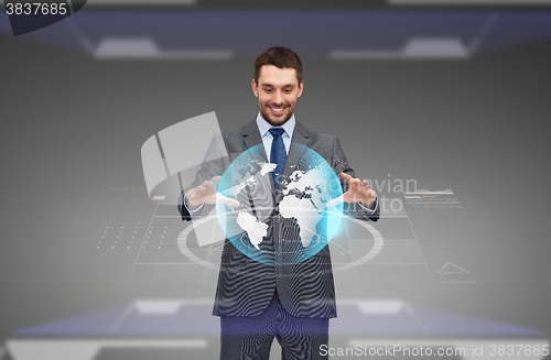 Image of businessman with virtual earth globe projection