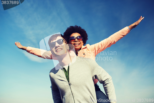 Image of happy teenage couple in shades having fun outdoors