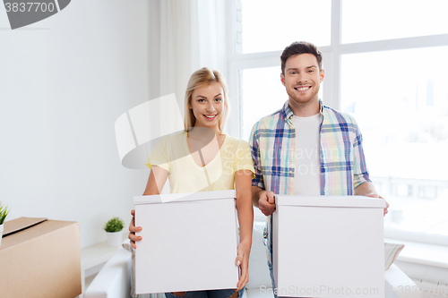 Image of smiling couple with big boxes moving to new home