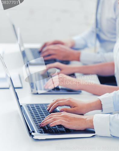 Image of group of people working with laptops in office