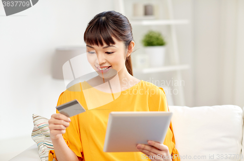 Image of happy asian woman with tablet pc and credit card