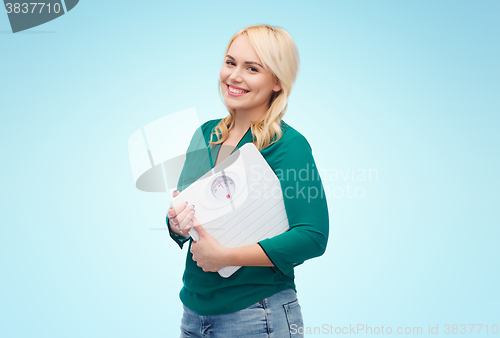 Image of smiling young woman holding scales