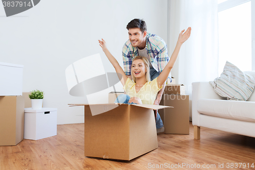 Image of happy couple having fun with boxes at new home