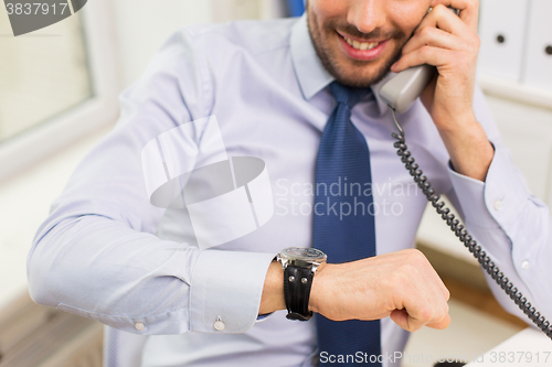 Image of businessman dialing number and calling on phone