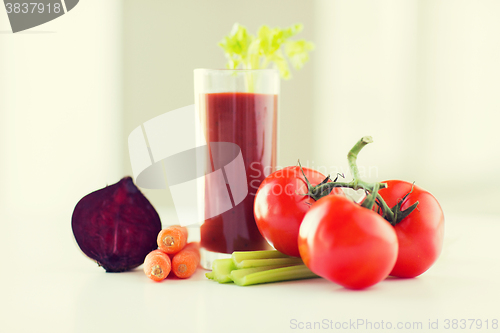 Image of close up of fresh juice and vegetables on table