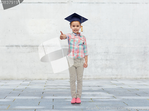 Image of happy girl in bachelor hat showing thumbs up