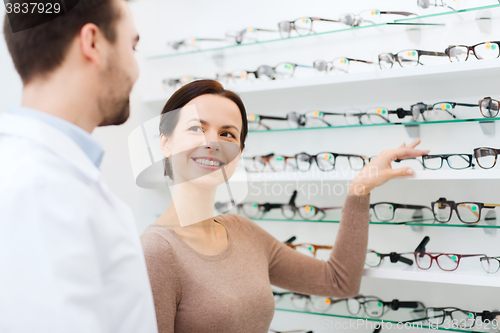 Image of woman showing glasses to optician at optics store